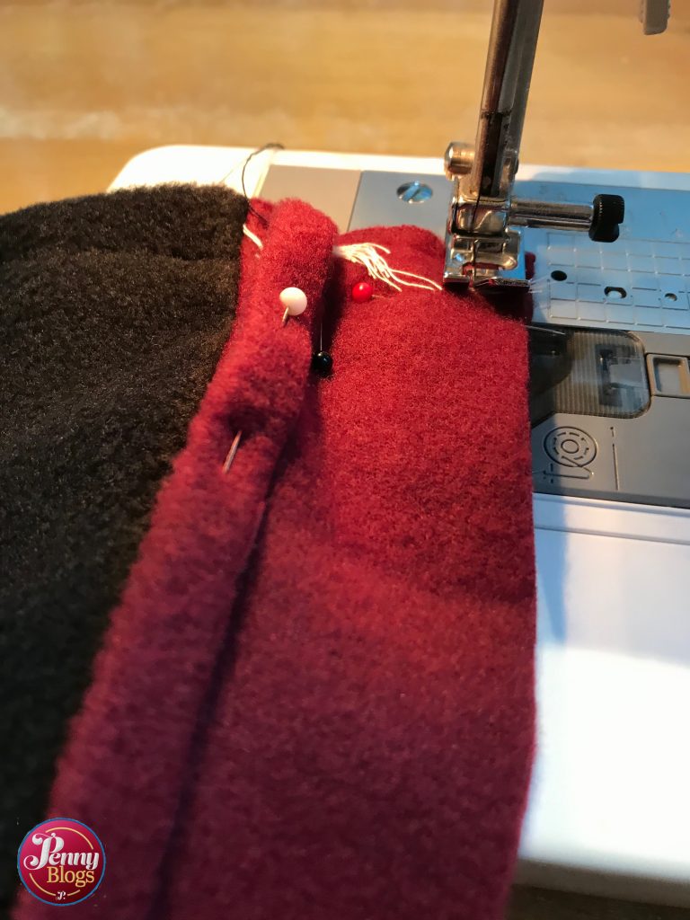 A close up showing a piece of wine red fleece on the sewing machine