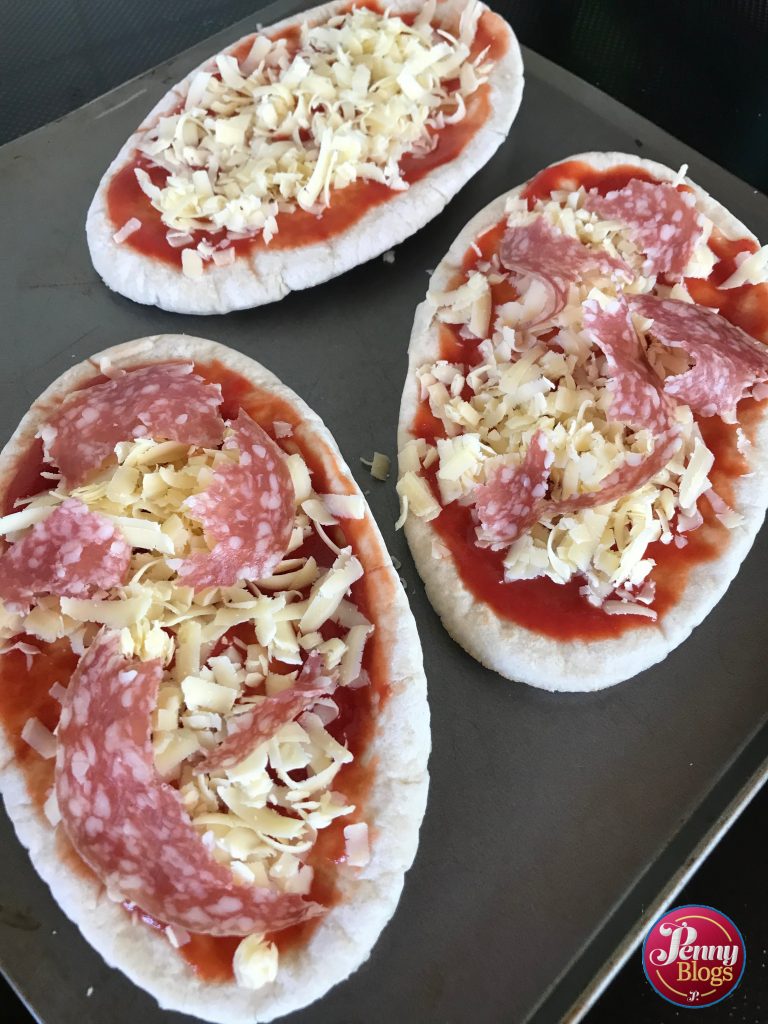 Three pitta bread pizzas ready for the oven